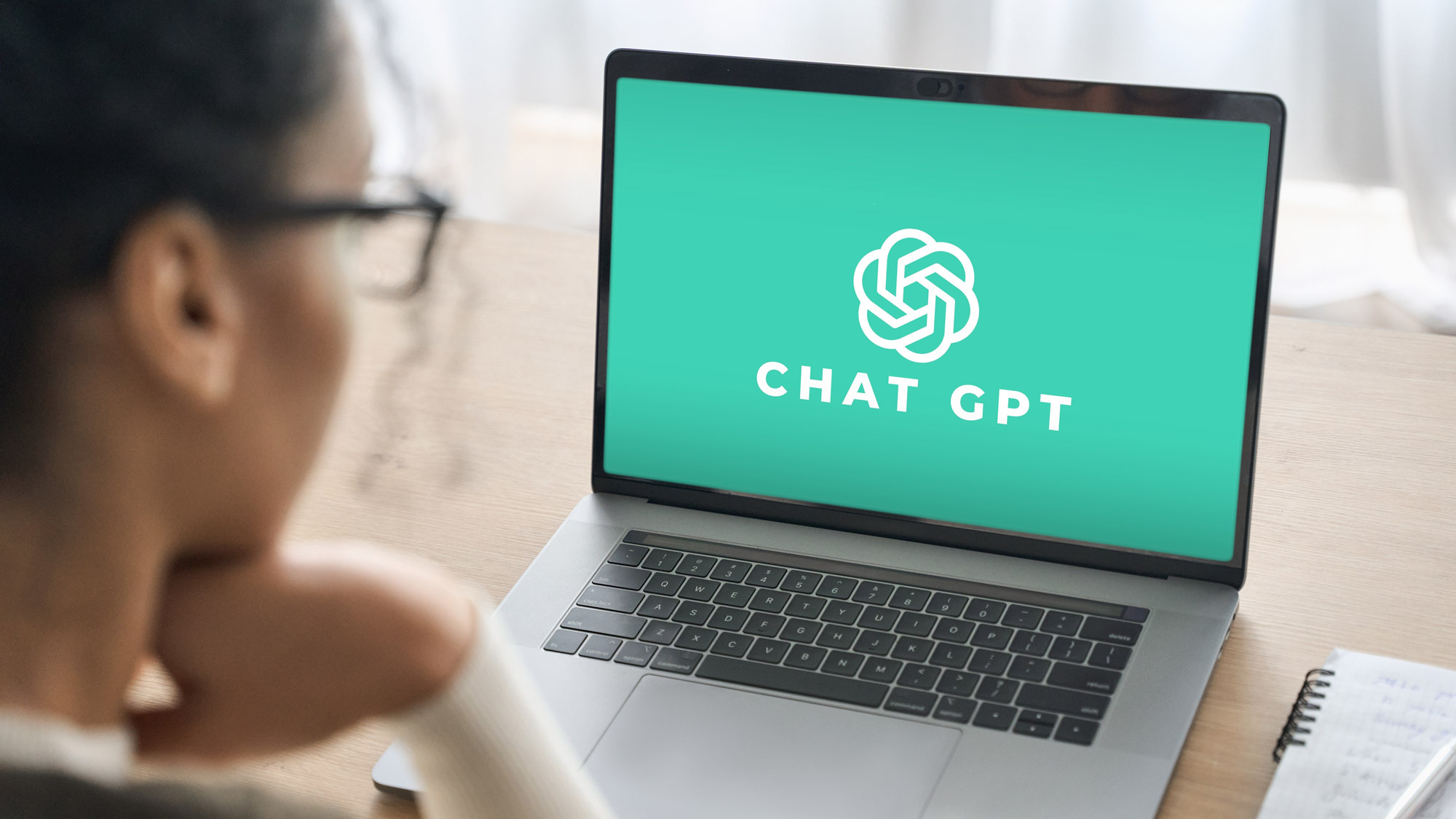 một phụ nữ đang sử dụng ChatGPT AI trên một chiếc laptop